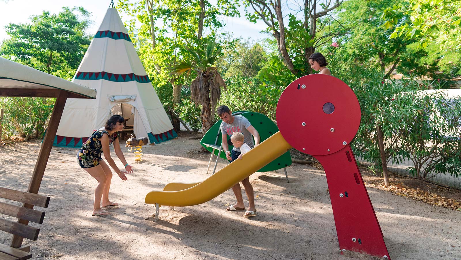 Toboggan et tipi sur l'aire de jeu du club enfants du camping