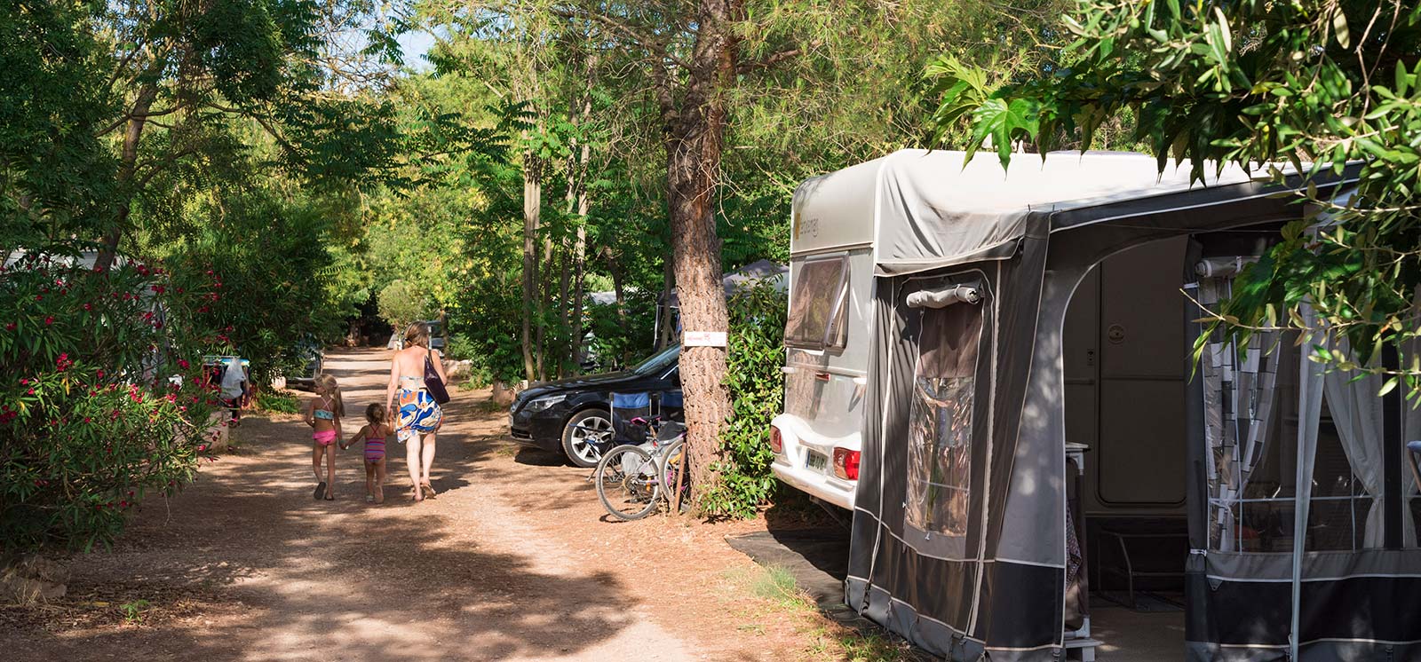 Promeneurs dans l'allée et emplacement pour caravane près de Salagou