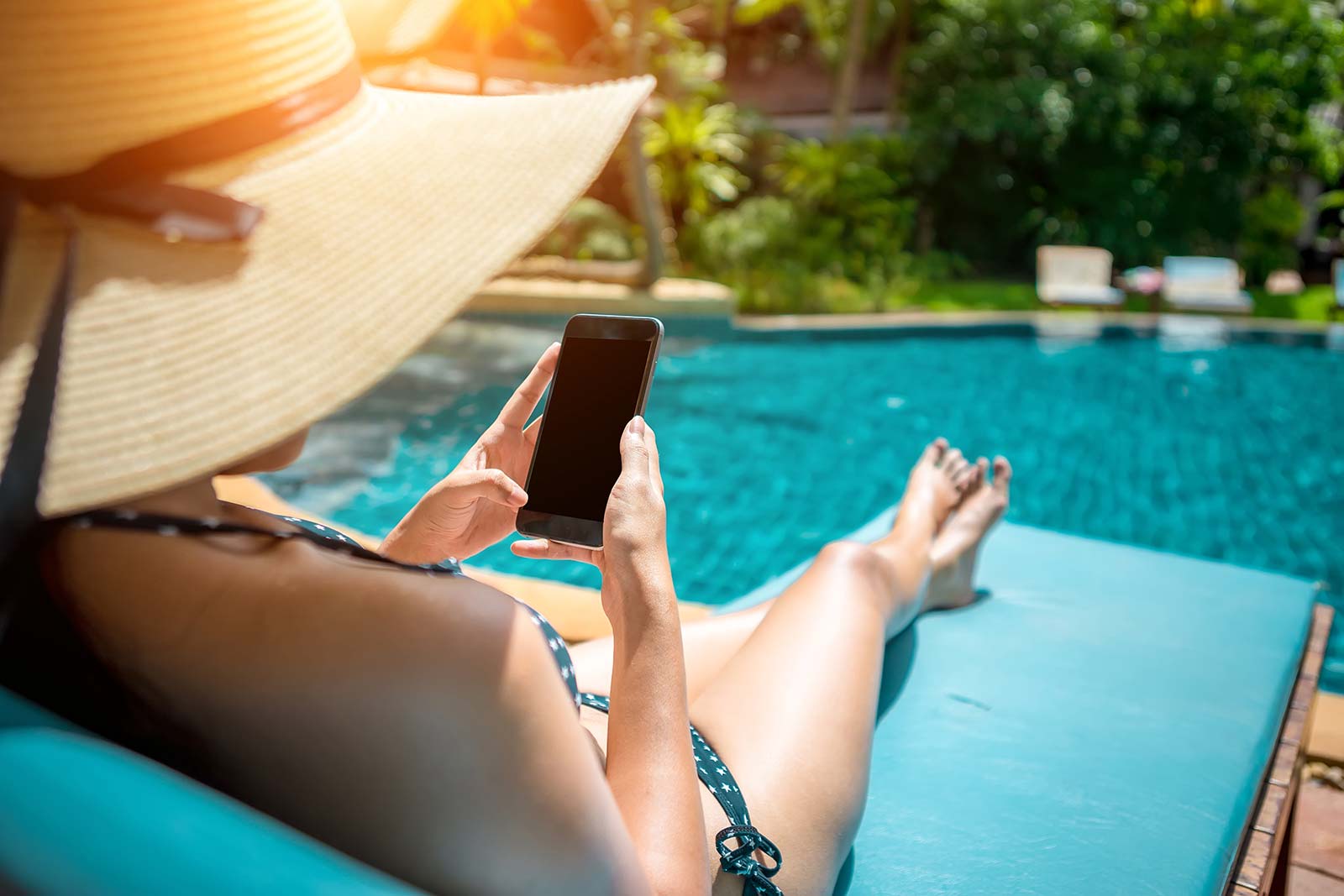 Femme bronzant au bord de la piscine du camping Les Rivières