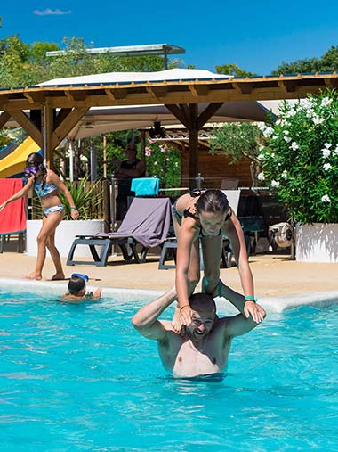 Fillette et son père dans l'espace aquatique du camping près de Béziers