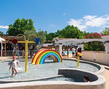 Jeux aquatiques dans la pataugeoire pour enfants au camping Les Rivières