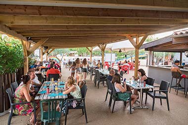 Table on the covered terrace of the Les Rivières campsite restaurant