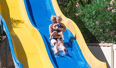 Femme avec son bébé à l'arrivée d'un toboggan aquatique au camping près de Béziers