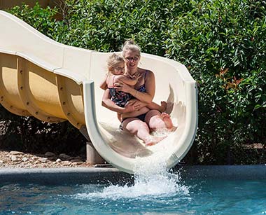 Arrivée du toboggan aquatique avec une femme et son bébé au camping à Canet dans Hérault