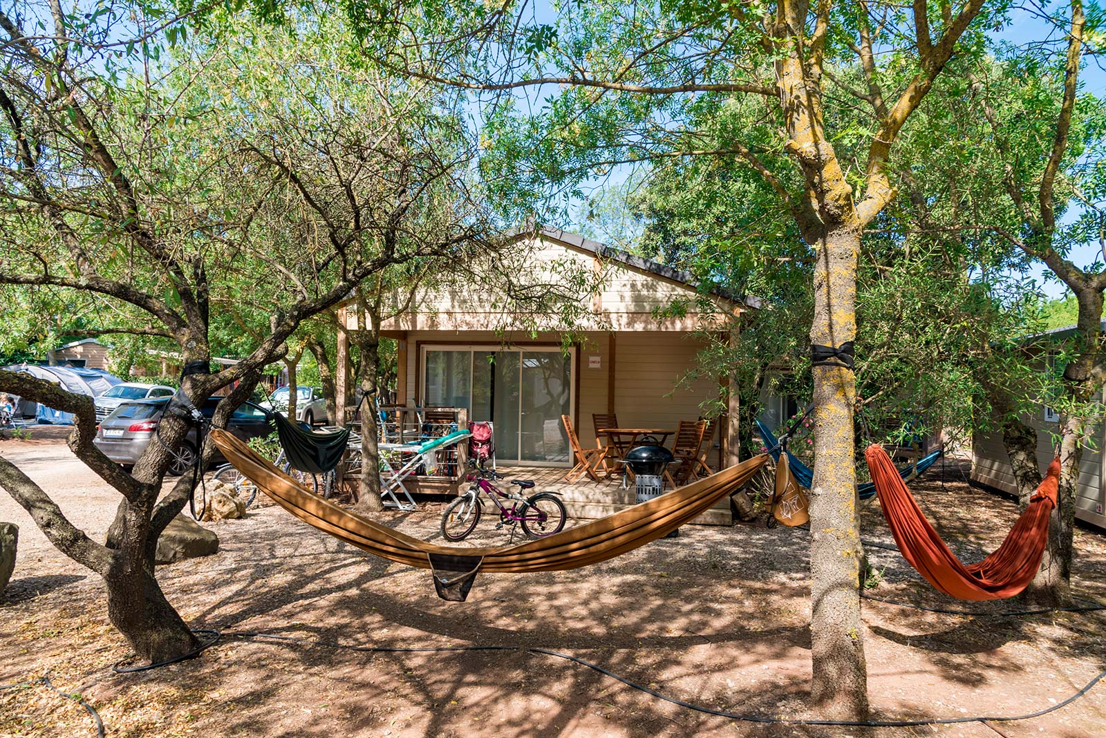Hammock in front of a mobile home in the park of Les Rivières campsite