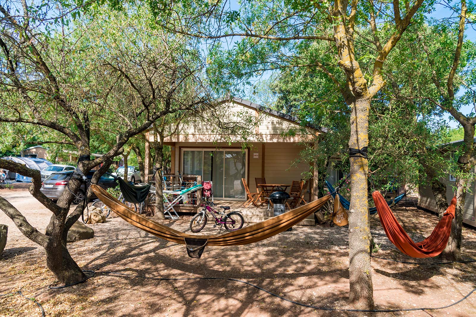 Hamac devant un mobil-home dans le parc du camping Les Rivières