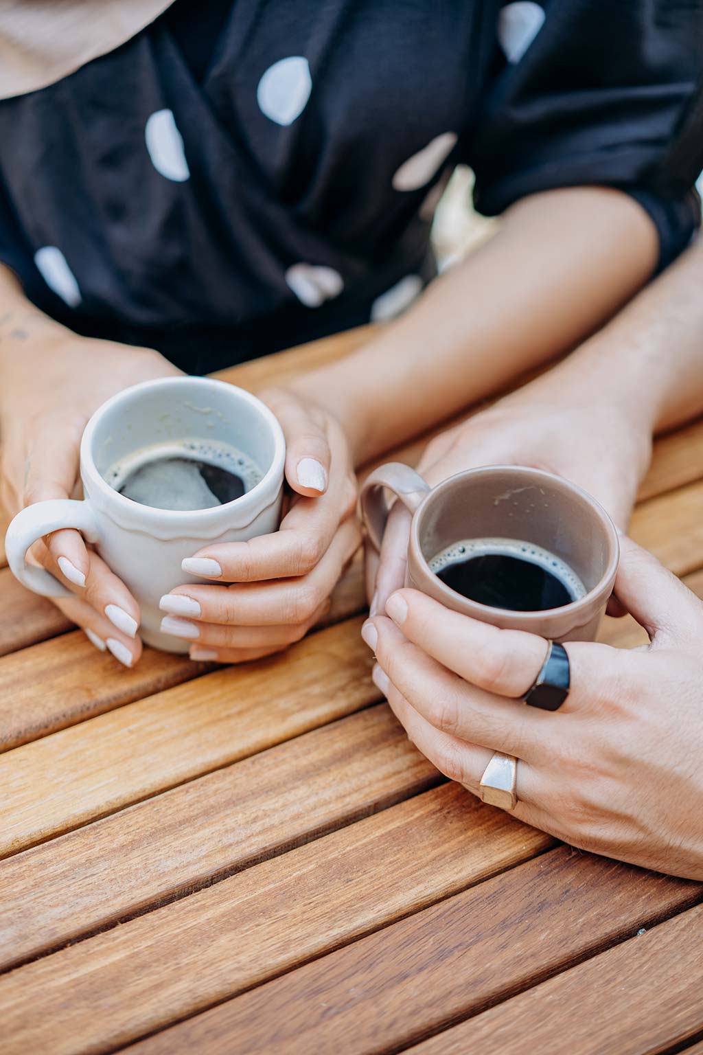 Tasse de café tenues en main sur une table d'un gîte près de Salagou