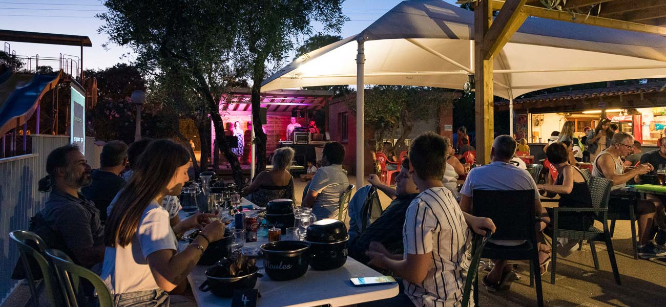 Terrace of the restaurant bar at Les Rivières campsite during an evening entertainment